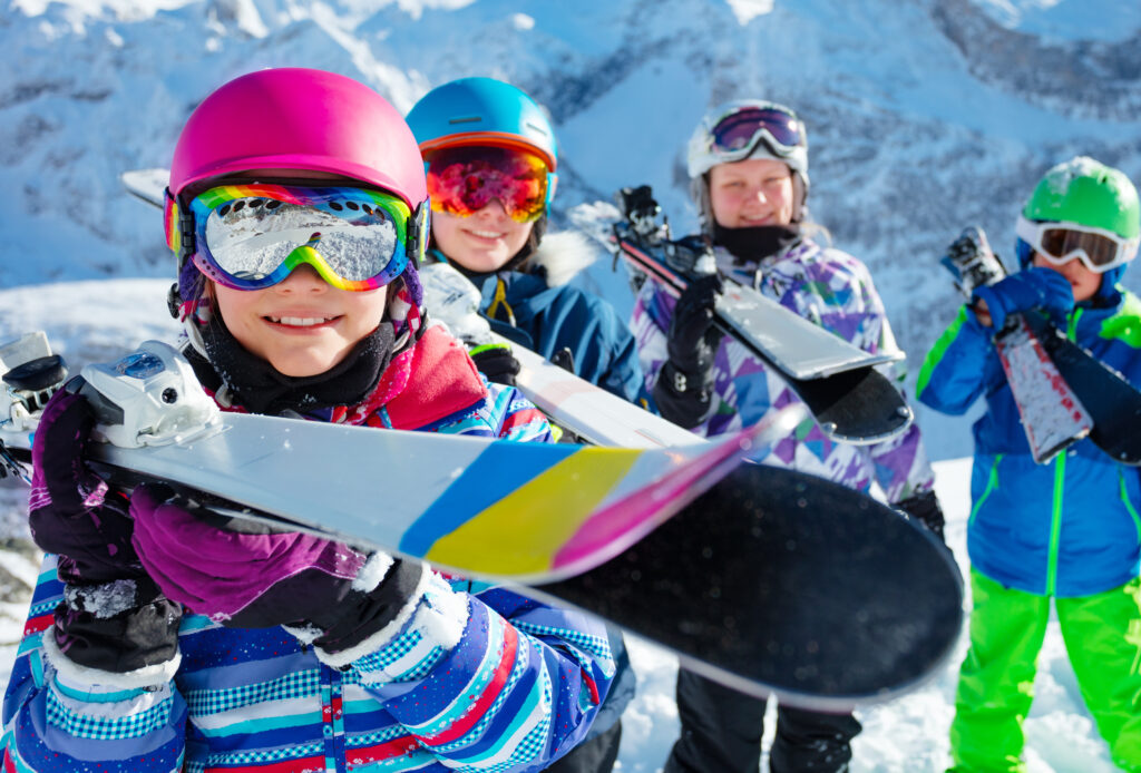 Groupe d'enfants du ski club avec les montagnes en arrière-plan.