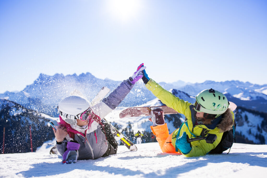 Des enfants équipés pour le ski et le snowboard s'amusent.